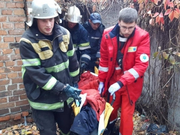 Кременчугские спасатели вытащили бездомного, застрявшего между забором и зданием
