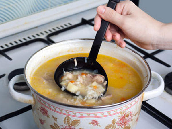 суп в емальованій каструлі на плиті