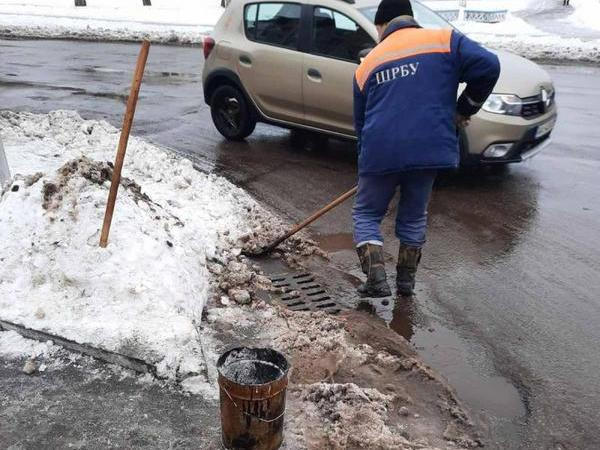 Для оперативного пропуска талых вод кременчугские дорожники расчищают ливневки от снега